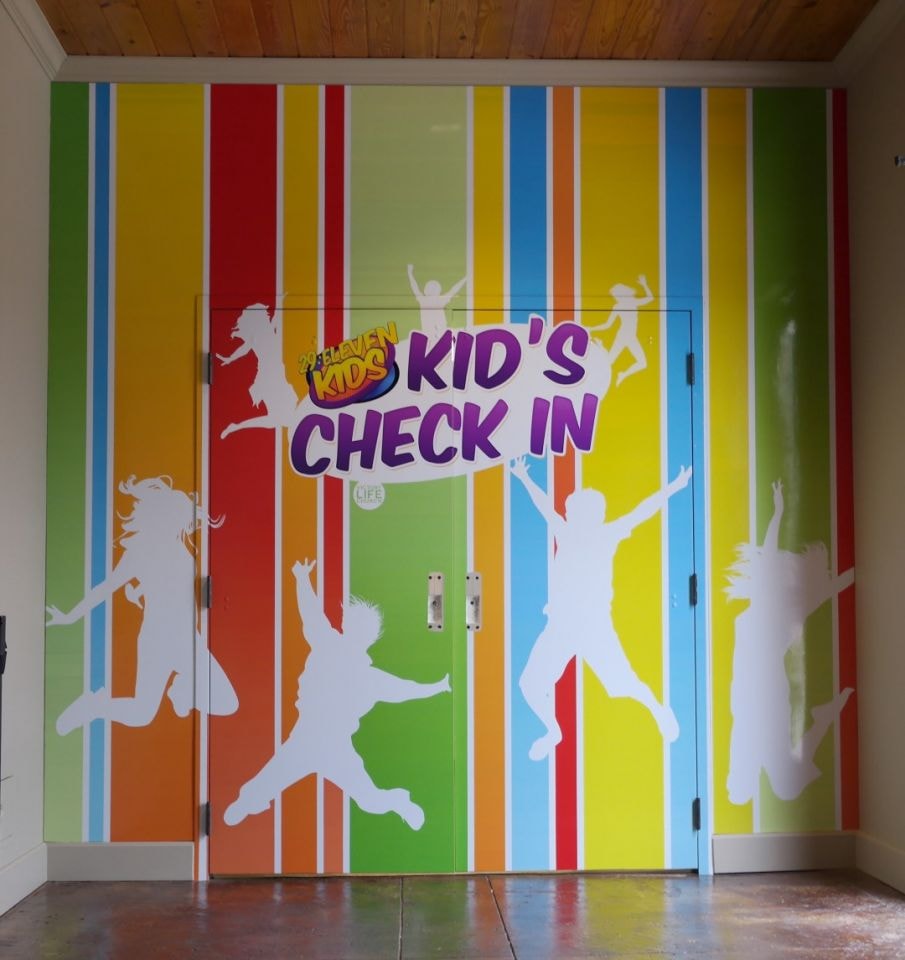 Victory Life Church kids check-in colorful wall wrap with children silhouettes and rainbow stripes by Architectural Wraps