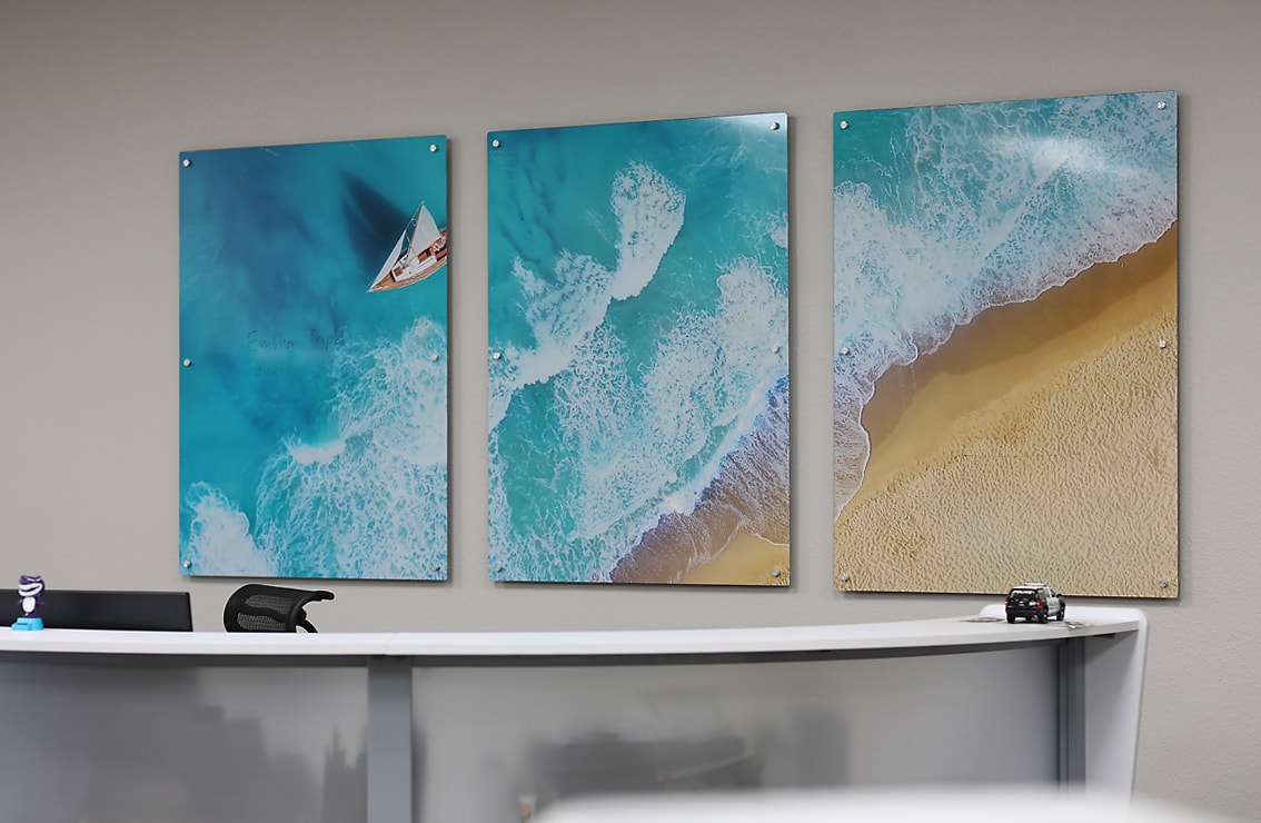 Office reception wall with three dry-erase coastal aerial ocean photo panels mounted on standoffs by Architectural Wraps
